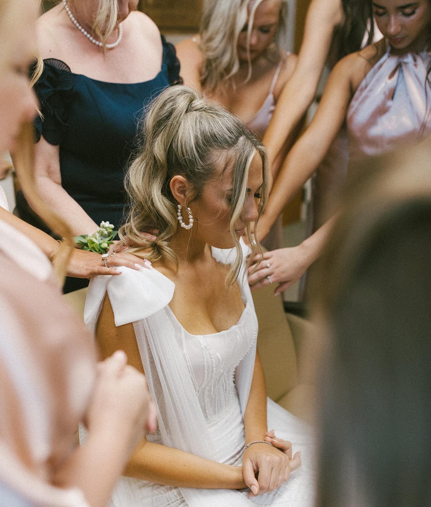 Bride with a curly high ponytail and pearl earrings